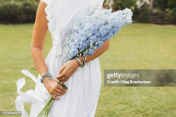 bouquet of blue delphinium flowers in bride's hands close-up. bijouterie bracelets on hands - ブーケ　花嫁 ストックフォトと画像