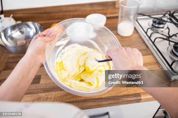 woman mixing eggs and cake filling - cheesecake white stockfoto's en -beelden