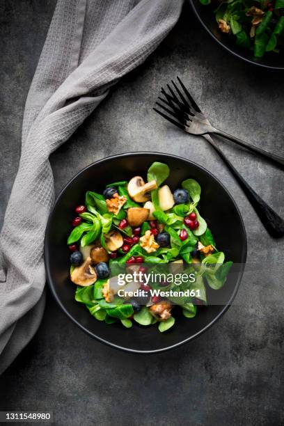 autumn salad consisting of lambs lettuce, mushrooms, fried pears, blueberries, pomegranate seeds and walnuts - mache stock pictures, royalty-free photos & images