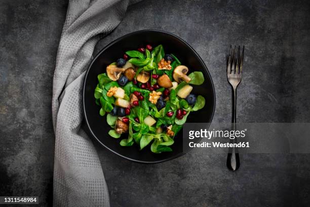 autumn salad consisting of lamb's lettuce, mushrooms, fried pears, blueberries, pomegranate seeds and walnuts - mache stock pictures, royalty-free photos & images