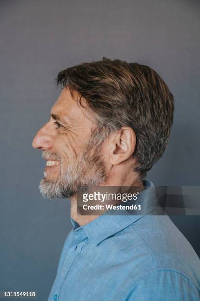 smiling man over gray background - profile stock-fotos und bilder