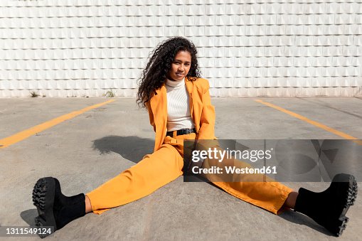 Beautiful woman sitting with legs apart on footpath Beautiful woman sitting with legs apart on footpath