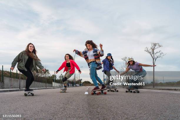 female friends enjoying skates riding on road during weekend - 20 20 vision bildbanksfoton och bilder