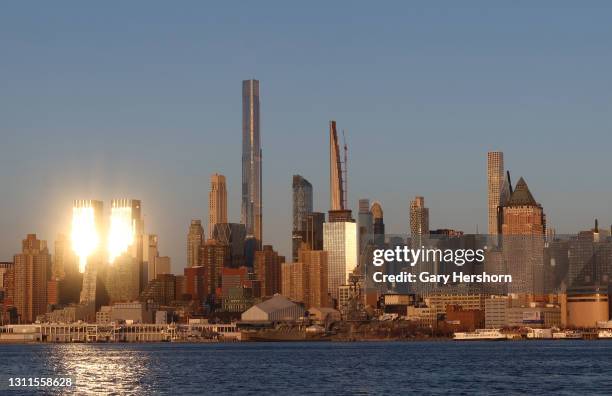 The sun reflects off of the Time Warner Center next to Central Park Tower and buildings along Billionaires' Row in New York City on April 8, 2021 as...