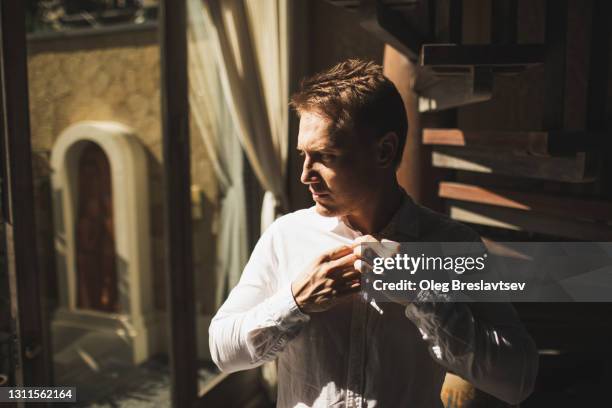 silhouette of groom in interior with beautiful sun light. man getting ready before wedding - face high contrast stock pictures, royalty-free photos & images