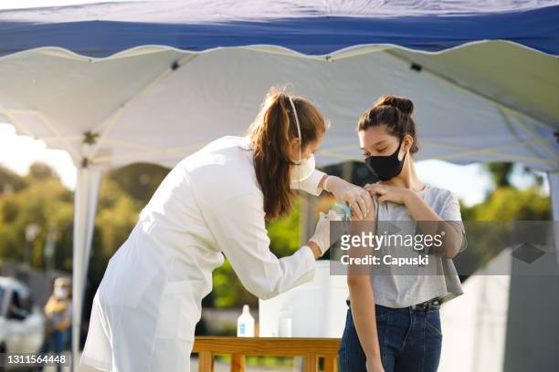 teen girl taking covid vaccine 19 - brazil covid stock pictures, royalty-free photos & images