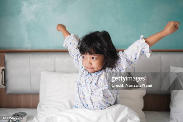 asian little child girl wakeup in the morning. stretching herself and exercise for relaxation - daily sport girls bildbanksfoton och bilder