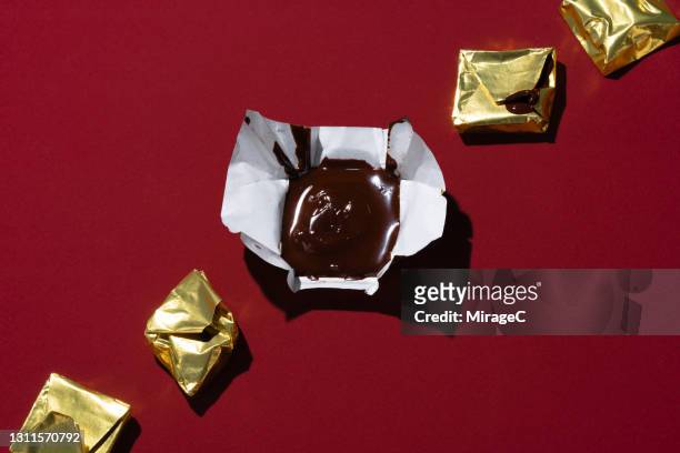 melted and deformed chocolate in gold wrapper - unwrapped stock pictures, royalty-free photos & images