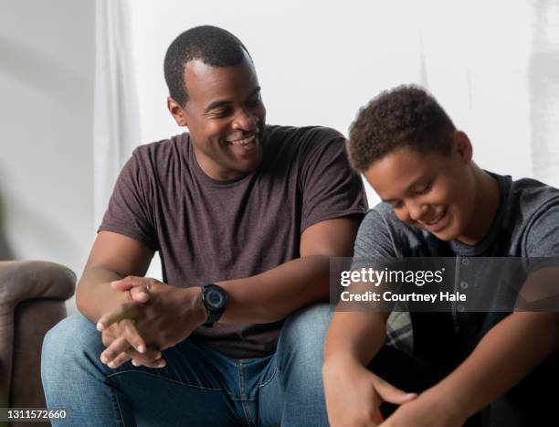 father gives life advice to his young teenage son at home - guru imagens e fotografias de stock