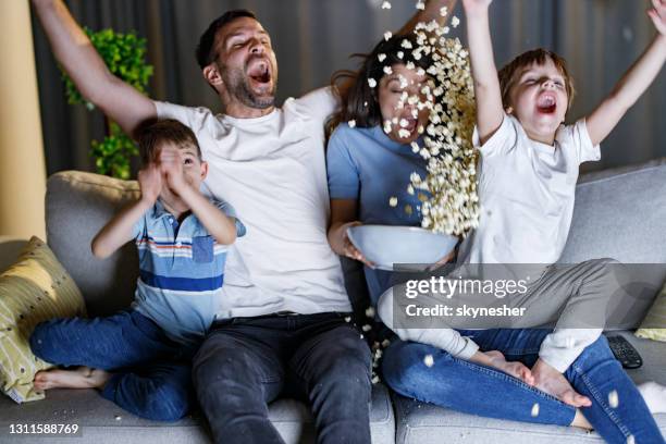 vrolijke familie die van vreugde schreeuwt terwijl het letten op sportengelijke thuis. - tv family stockfoto's en -beelden