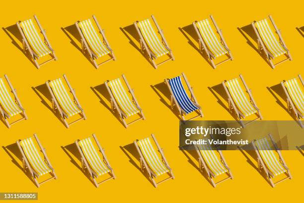 striped beach chair pattern on yellow background with copy space - duality stock-fotos und bilder