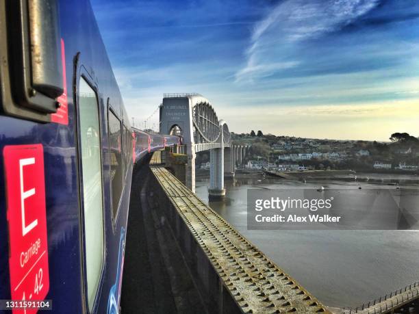train travelling passing over bridge at sunset - plymouth devon stock-fotos und bilder