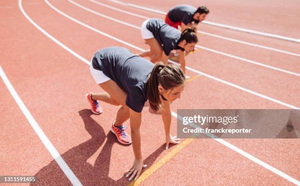 athlete on the running track ready for the start - university athletics stock pictures, royalty-free photos & images