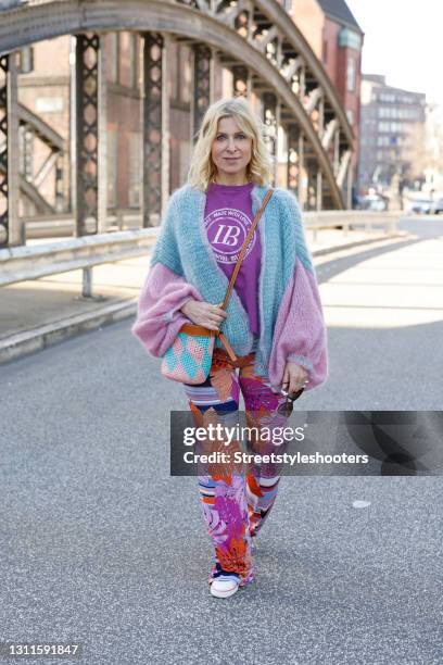 Influencer Carina Grendel wearing sunglasses by Saint Laurent, a purple shirt by Liv Bergen, multicolor floral print pants by Stegmann Hamburg, white...