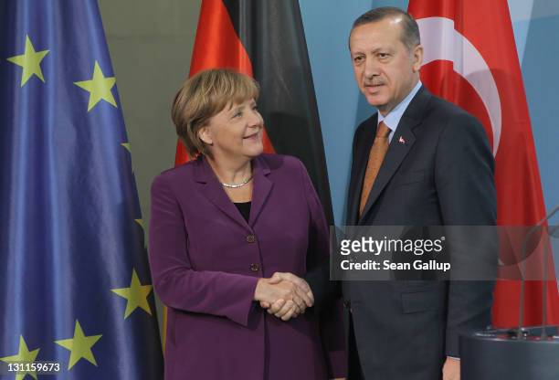 German Chancellor Angela Merkel and Turkish Prime Minister Recep Tayyip Erdogan shake hands after speaking to the media following talks at the...