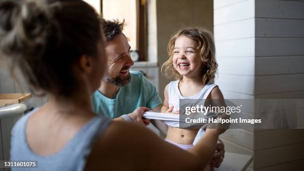 family with small daughter in bathroom at home, preparing for a bath. - bathroom night stockfoto's en -beelden