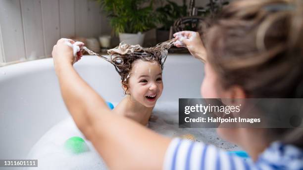 mother with small daughter in bathroom at home, having fun in bath. - お風呂　親子 ストックフォトと画像