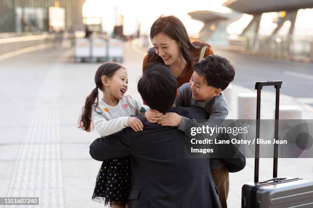 happy young family at airport - wiedersehenstreffen stock-fotos und bilder