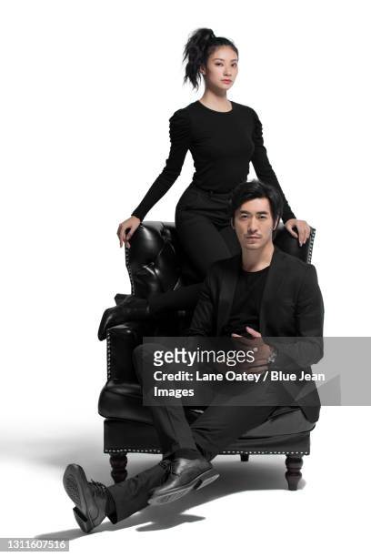 fashionable couple sitting on a luxury sofa - well dressed couple isolated stock pictures, royalty-free photos & images