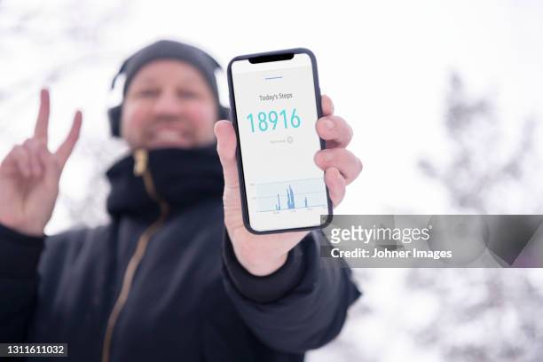 man holding smart phone and showing step tracker - pedometer stock pictures, royalty-free photos & images