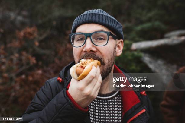 man eating hotdog - hotdog stockfoto's en -beelden