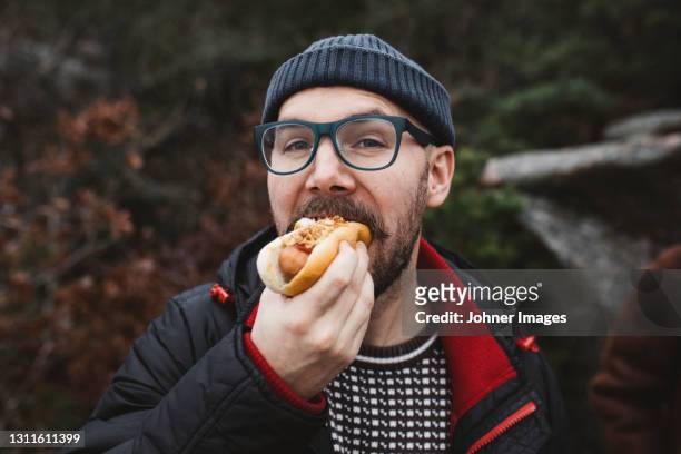 man eating hotdog - hot dog stock pictures, royalty-free photos & images