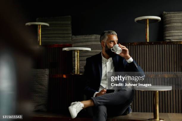 businessman drinking coffee in cafe - geschäftsmann im büro mobiltelefon stock-fotos und bilder