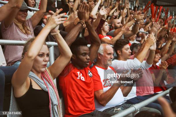 fans on the stadium cheering - football cheering stock pictures, royalty-free photos & images