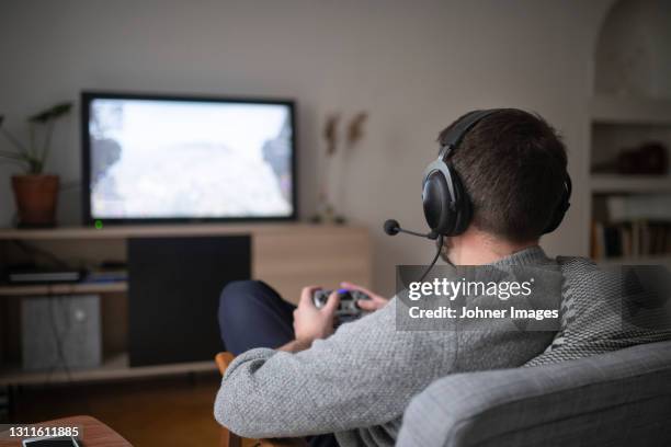 man with headset playing video game - gamepad stock pictures, royalty-free photos & images