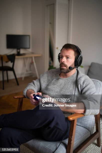 man with headset playing video game - joypad foto e immagini stock