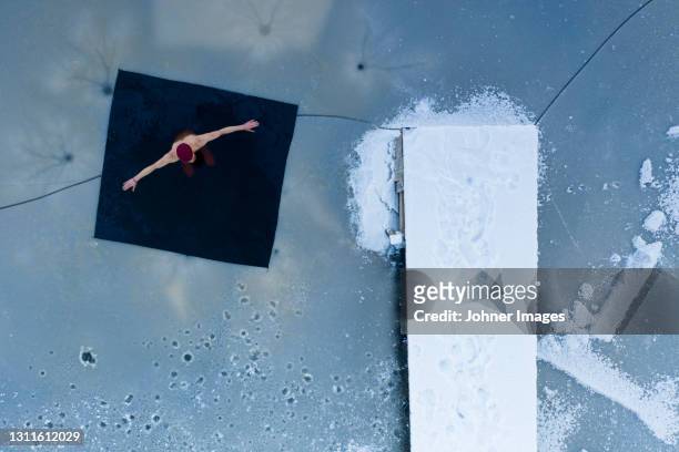 man swimming in frozen lake - bathing jetty stock pictures, royalty-free photos & images