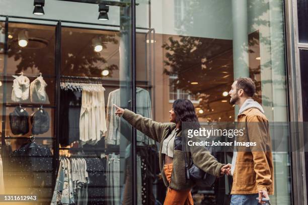 couple looking at shop window - store window stock pictures, royalty-free photos & images