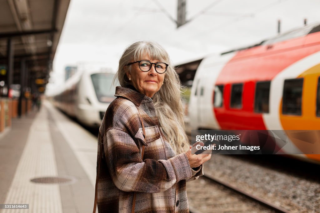 Mature woman at train station