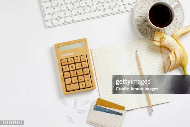 banana and coffee on desk - diet journal - fotografias e filmes do acervo