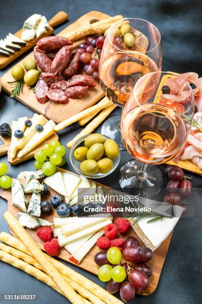 two glasses of rose wine with cheese and salami, olives - charcuterie board 個照片及圖片檔