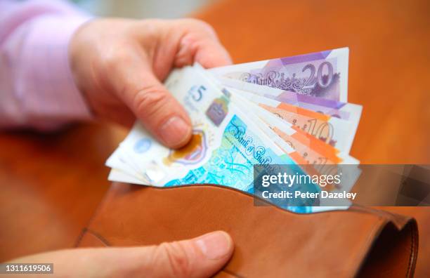 uk sterling, pound notes in wallet - elderly people stock pictures, royalty-free photos & images