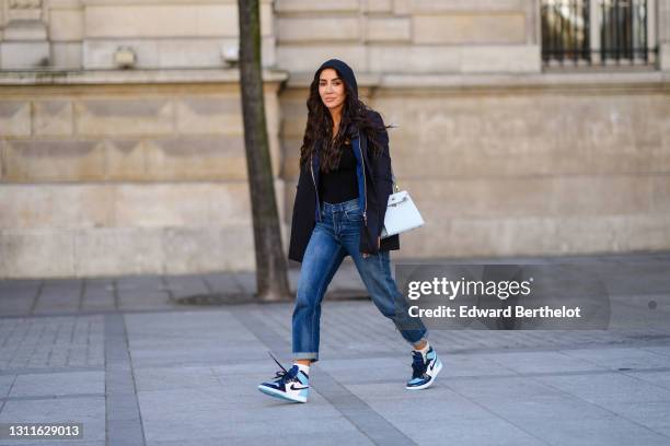 Tamara Kalinic wears a black striped oversized blazer jacket from Stella McCartney, a navy blue hoodie sweater from Vuitton, a black top, a pastel...