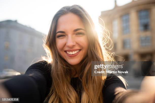 happy woman outside with sun in background - selfie imagens e fotografias de stock