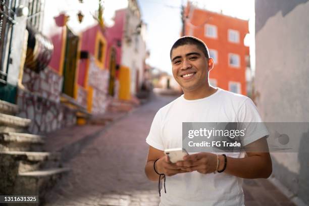 retrato de un joven usando smartphone en la calle - cultura americana fotografías e imágenes de stock