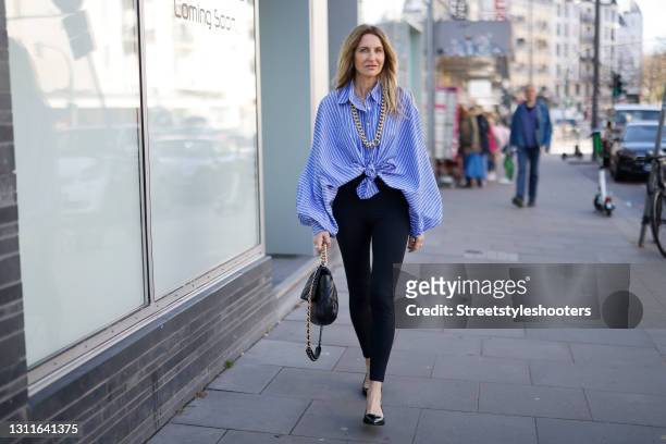 Fashion designer Sue Giers wearing black leggings by Norba, a black bag with gold details by Chanel, black sandals by Prada, a blue and white striped...