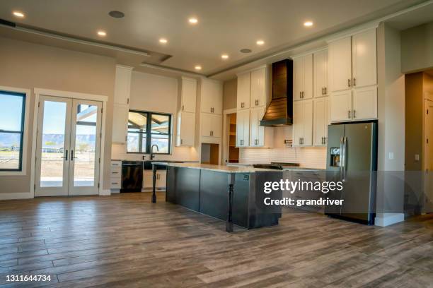 the kitchen interior of a newly constructed single family open concept home - downlight stock pictures, royalty-free photos & images