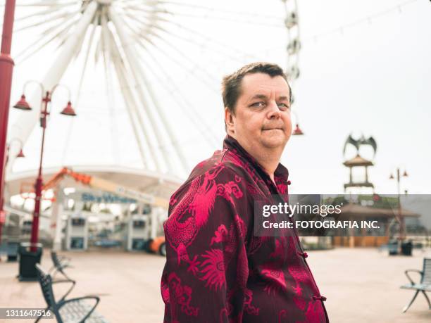 gay man feeling sad at amusement park - overweight 40 year old male concerned stock pictures, royalty-free photos & images