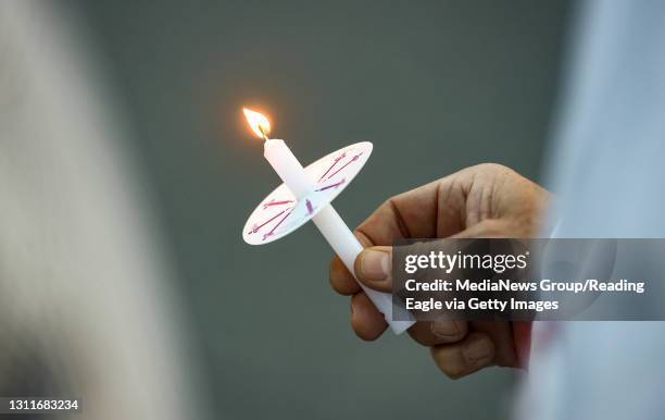 West Reading, PA A memorial attendee light holds a lit candle. At the Reading Hospital in West Reading, PA Thursday evening April 8, 2021 where the...