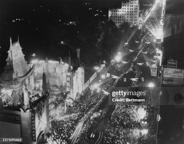 High angle view of the crowds gathered along an illuminated Hollywood Boulevard for the premiere of 'Hell's Angels', held at the Grauman's Chinese...