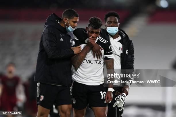 Mario Lemina of Fulham look dejected and is consoled by teammates Ruben Loftus-Cheek and Ola Aina of Fulham following their defeat in the Premier...