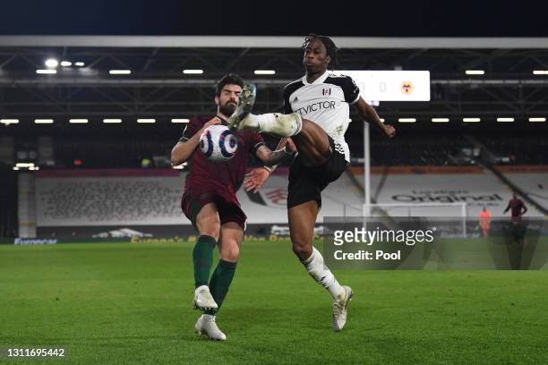 Terence Kongolo of Fulham battles for possession with Ruben Neves of Wolverhampton Wanderers during the Premier League match between Fulham and...