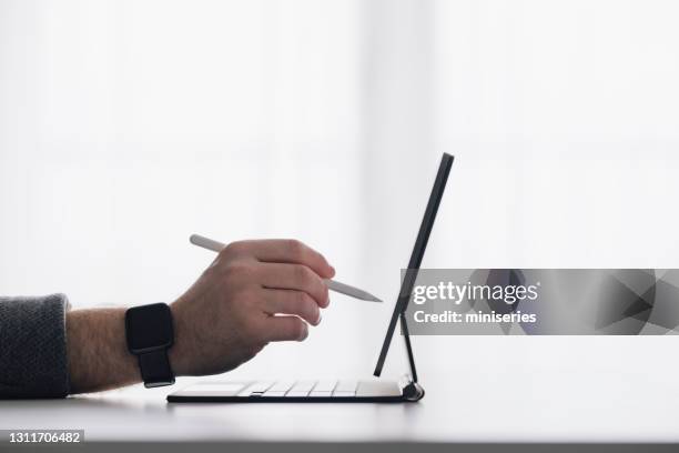 work at home: man using stylus pen - caneta digital imagens e fotografias de stock
