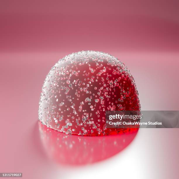 close-up of red gumdrop sprinkled with crystals of sugar. - gummy snoep stockfoto's en -beelden