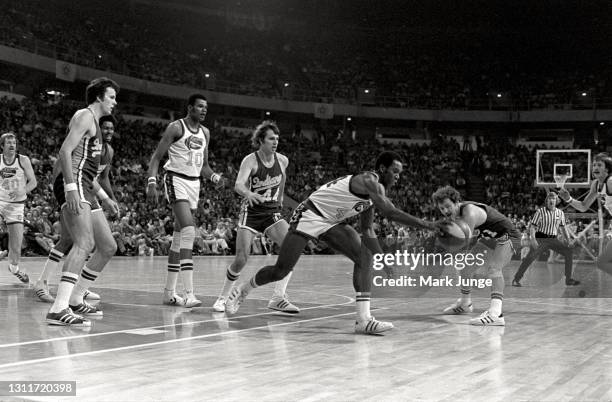 Denver Nuggets guard Ralph Simpson lunges for the ball while guarded by Bill Keller during an ABA basketball game against the Denver Nuggets at...