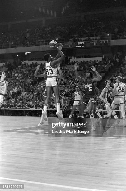 Denver Nuggets forward David Thompson shoots a jump shot over Indiana Pacers players Len Elmore and Travis Grant during an ABA basketball game at...